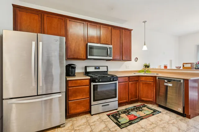 a kitchen with stainless steel appliances granite countertop a refrigerator stove top oven and sink