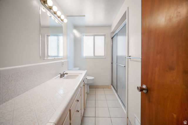 3233 Jean Street Magna, UT 84044 - Photo 24 of 33 Bathroom vanity with integrated sink, patterned tile backsplash, and a large mirror