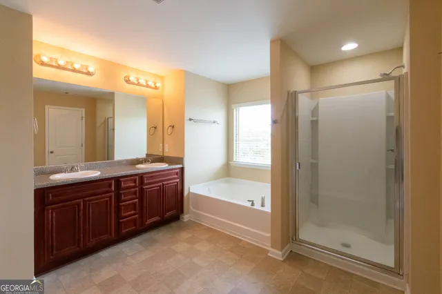 a bathroom with a tub sink shower and mirror