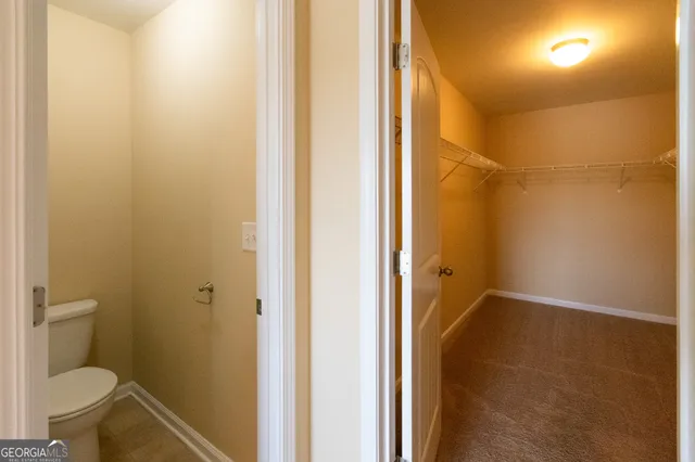 a bathroom with a granite countertop shower and a toilet