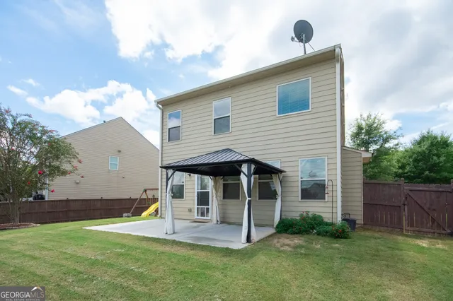 a view of a backyard with plants and a large tree