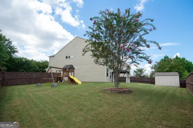 a view of a patio with table and chairs and potted plants with large tree