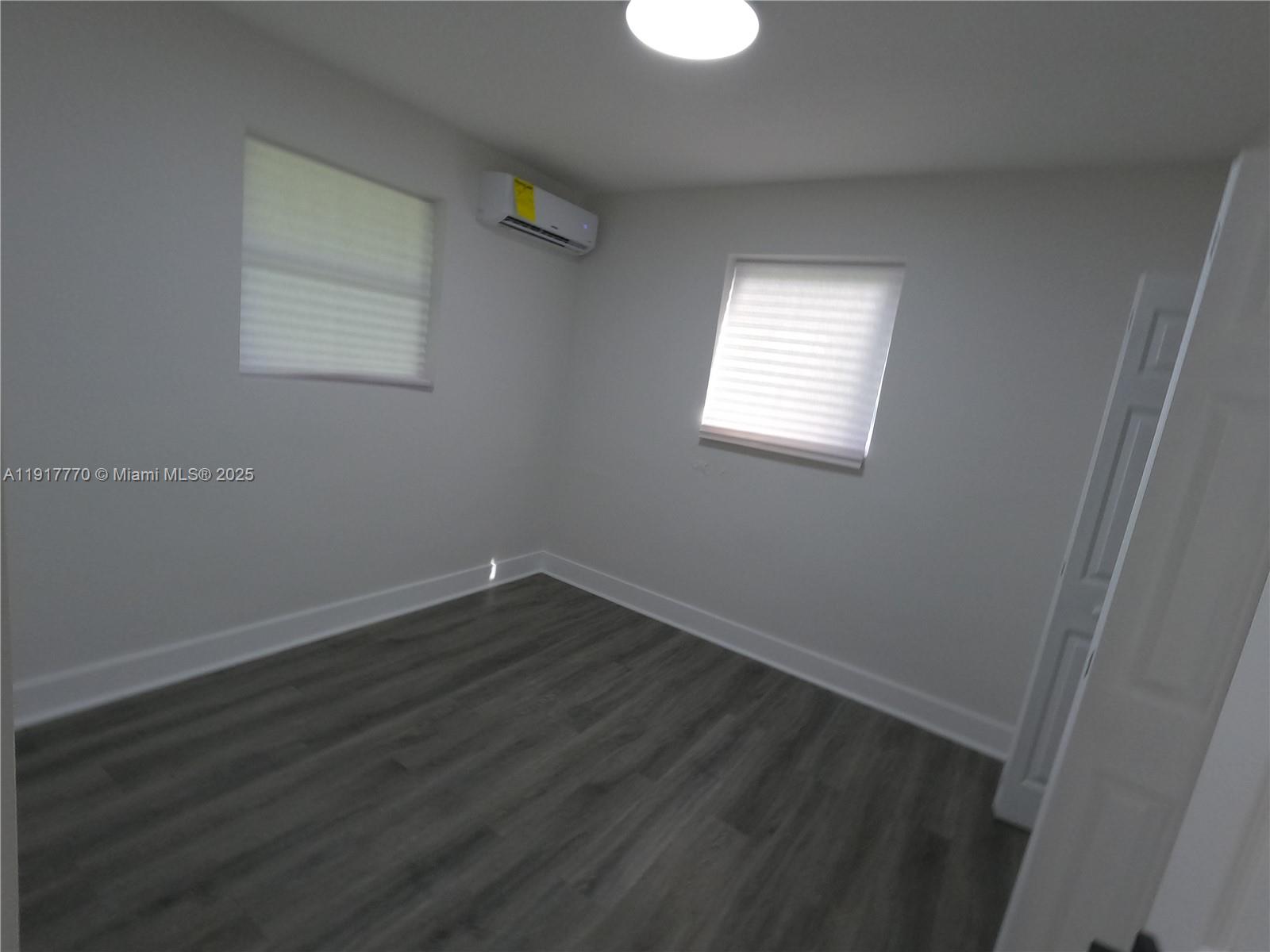 26633 Southwest 138th Court Homestead, FL 33032 - Photo 11 of 58 an empty room with wooden floor and windows