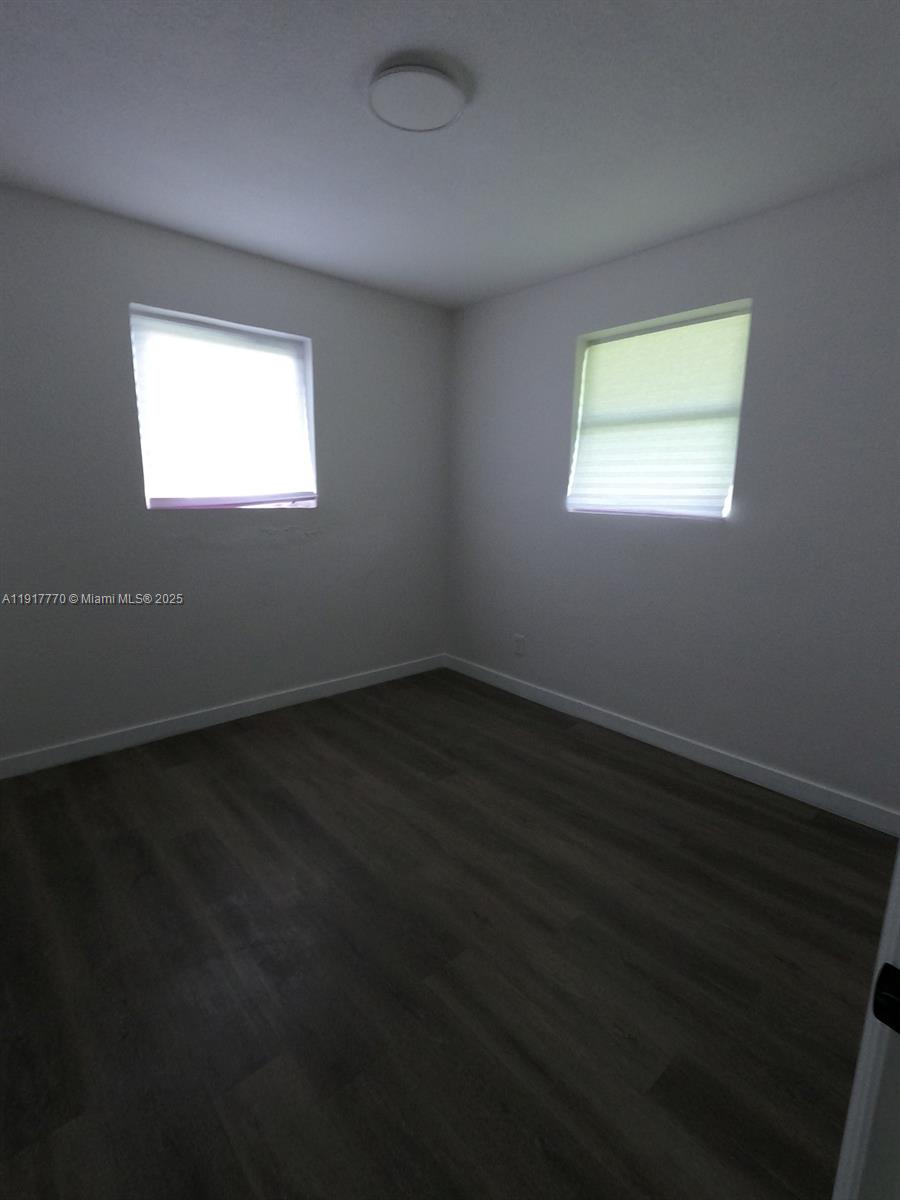 26633 Southwest 138th Court Homestead, FL 33032 - Photo 28 of 58 a view of an empty room with wooden floor and a window