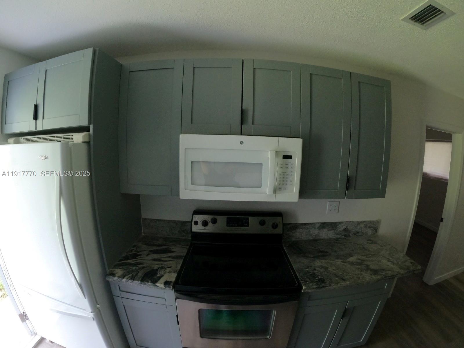 26633 Southwest 138th Court Homestead, FL 33032 - Photo 34 of 58 a kitchen with a stove and a refrigerator