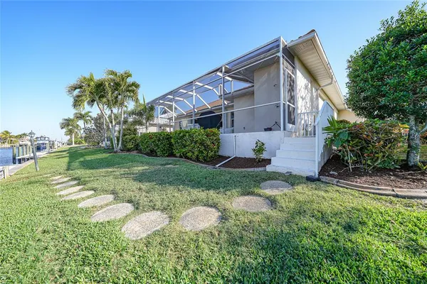 a view of a house with a yard and palm trees