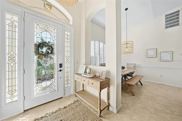 a dining room with furniture a chandelier and wooden floor