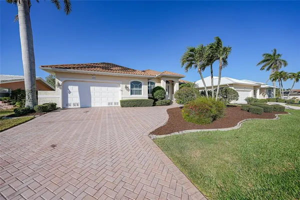 a front view of a house with a yard and palm tree