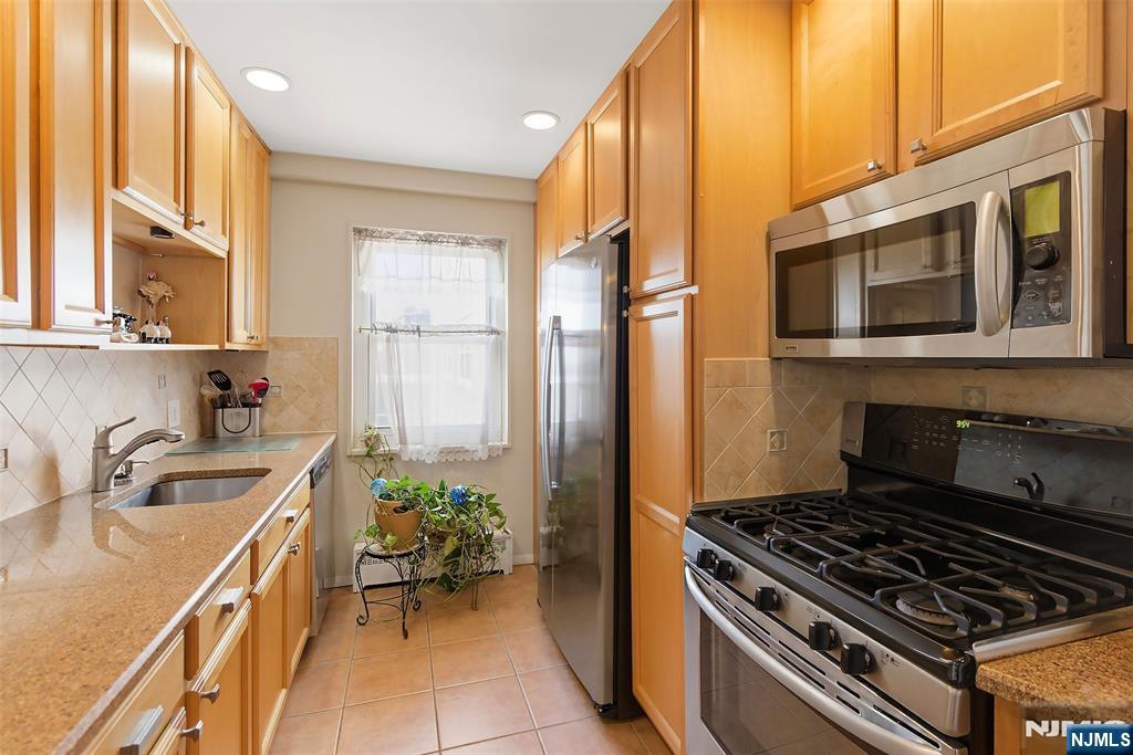 280 Prospect Avenue, Unit 8G Hackensack, NJ 07601 - Photo 8 of 23 a kitchen with a stove a sink and a microwave