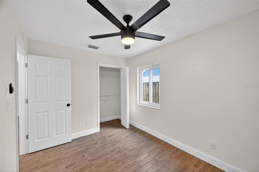 3733 Coppertree Circle Brandon, FL 33511 - Photo 28 of 45 an empty room with wooden floor ceiling fan and windows