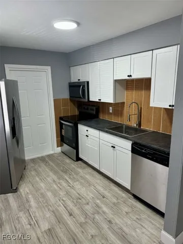 a kitchen with granite countertop a sink and steel appliances