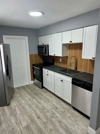 a kitchen with granite countertop a sink and steel appliances