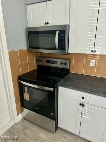 a kitchen with granite countertop a stove microwave and sink