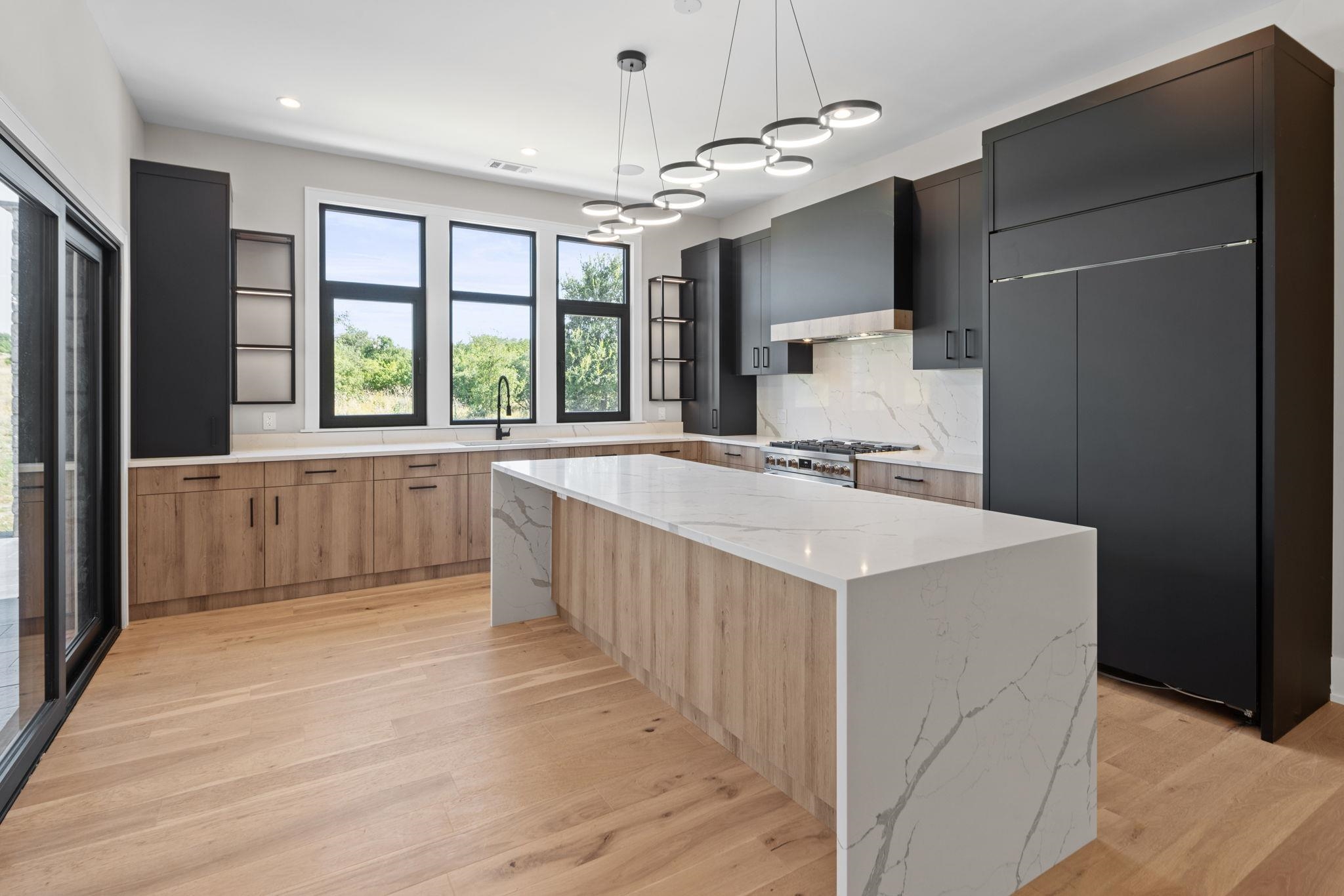 583 Comanche Ridge Round Mountain, TX 78663 - Photo 12 of 30 a large white kitchen with a large window a refrigerator and a sink