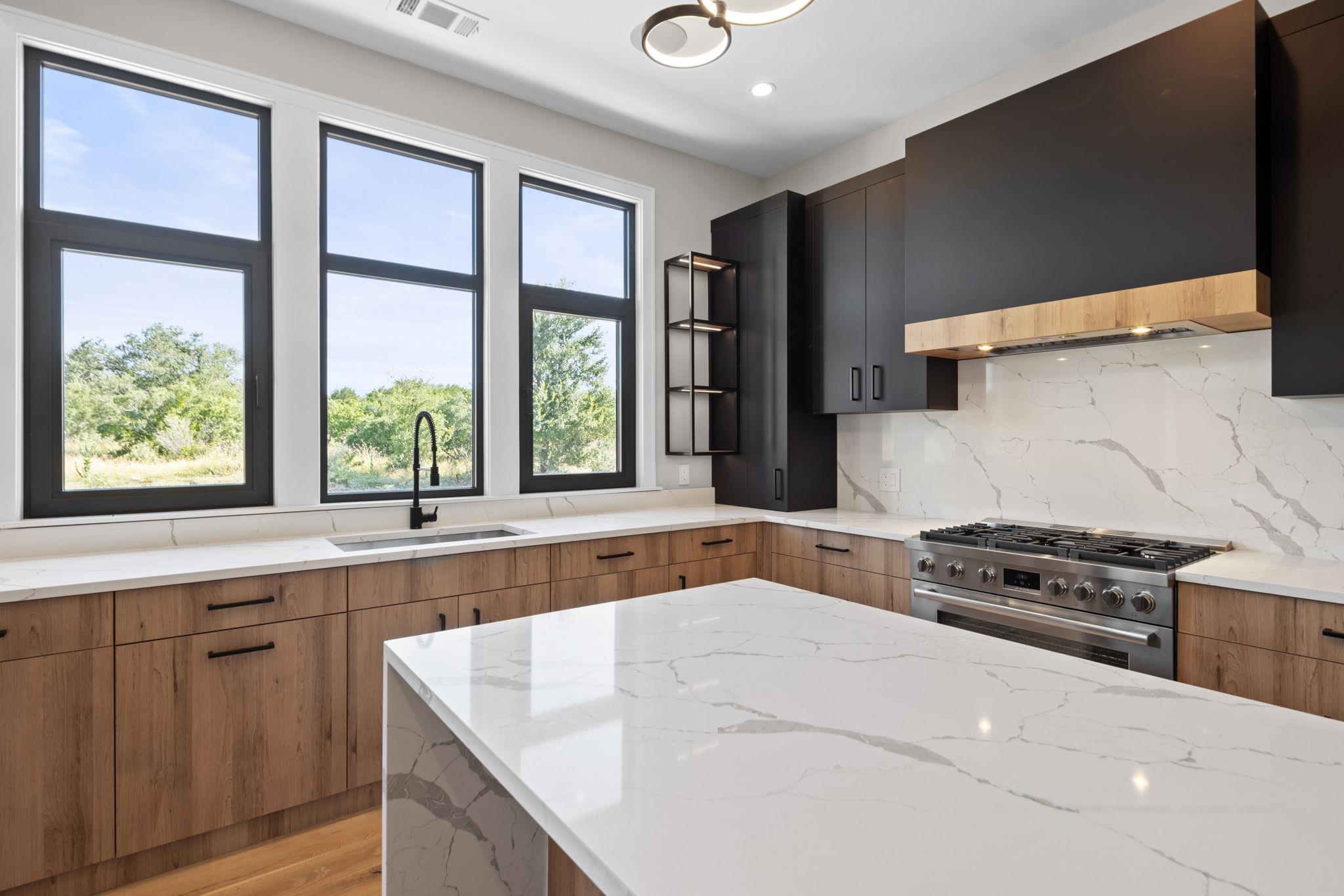 583 Comanche Ridge Round Mountain, TX 78663 - Photo 13 of 30 a kitchen with stainless steel appliances granite countertop a stove a sink and a microwave