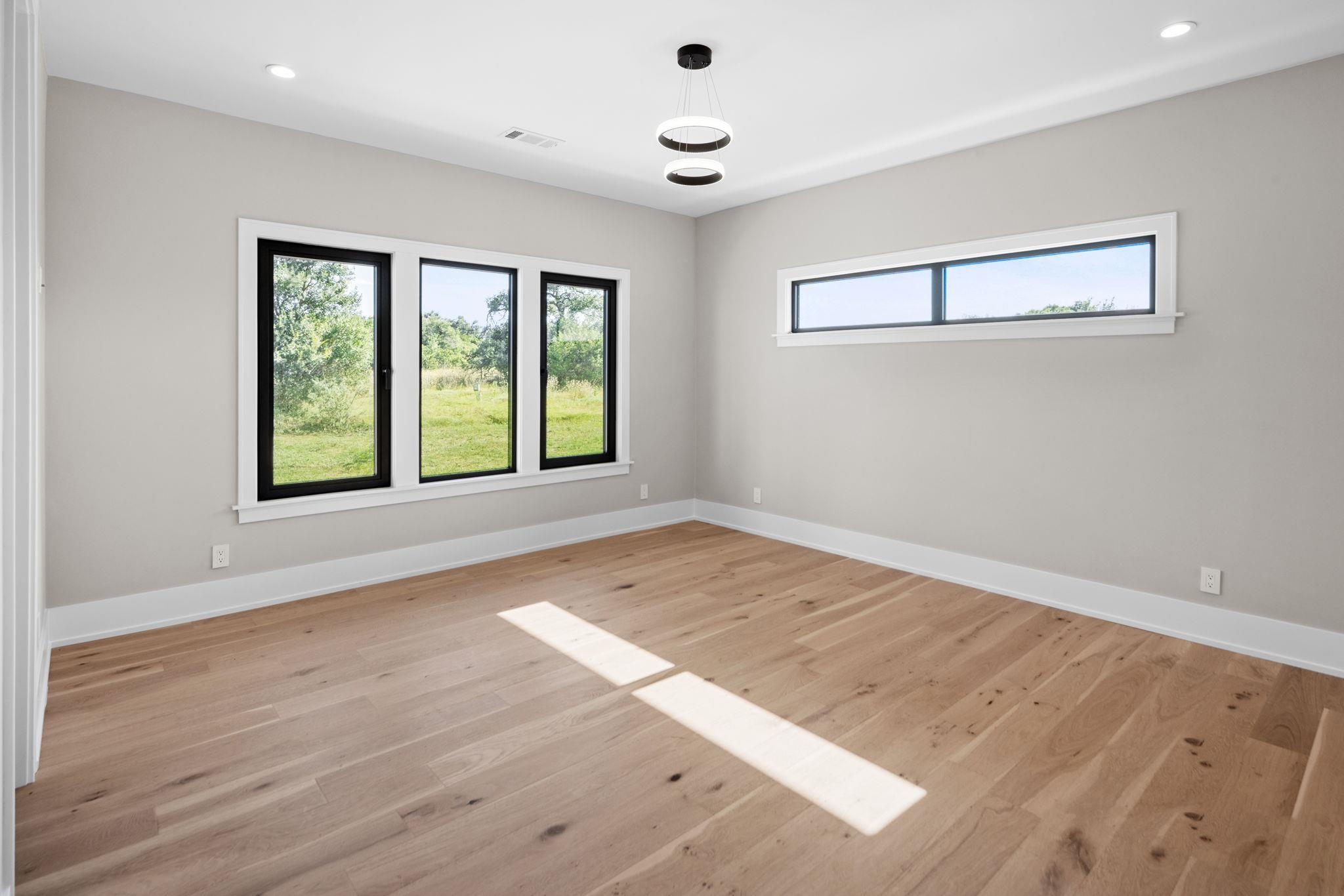 583 Comanche Ridge Round Mountain, TX 78663 - Photo 15 of 30 a view of an empty room with wooden floor and a window