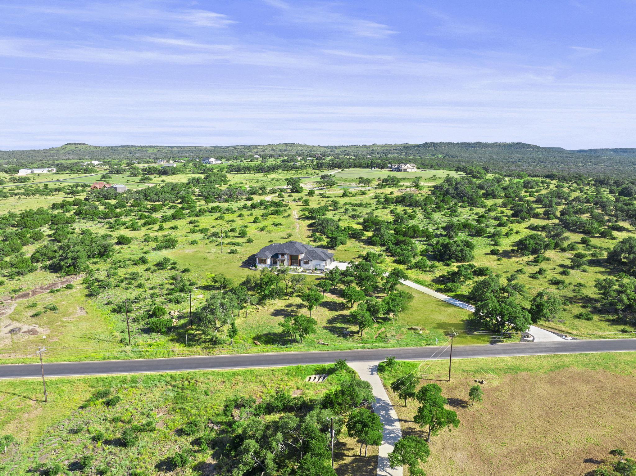 583 Comanche Ridge Round Mountain, TX 78663 - Photo 27 of 30 a view of a garden with a building in the background