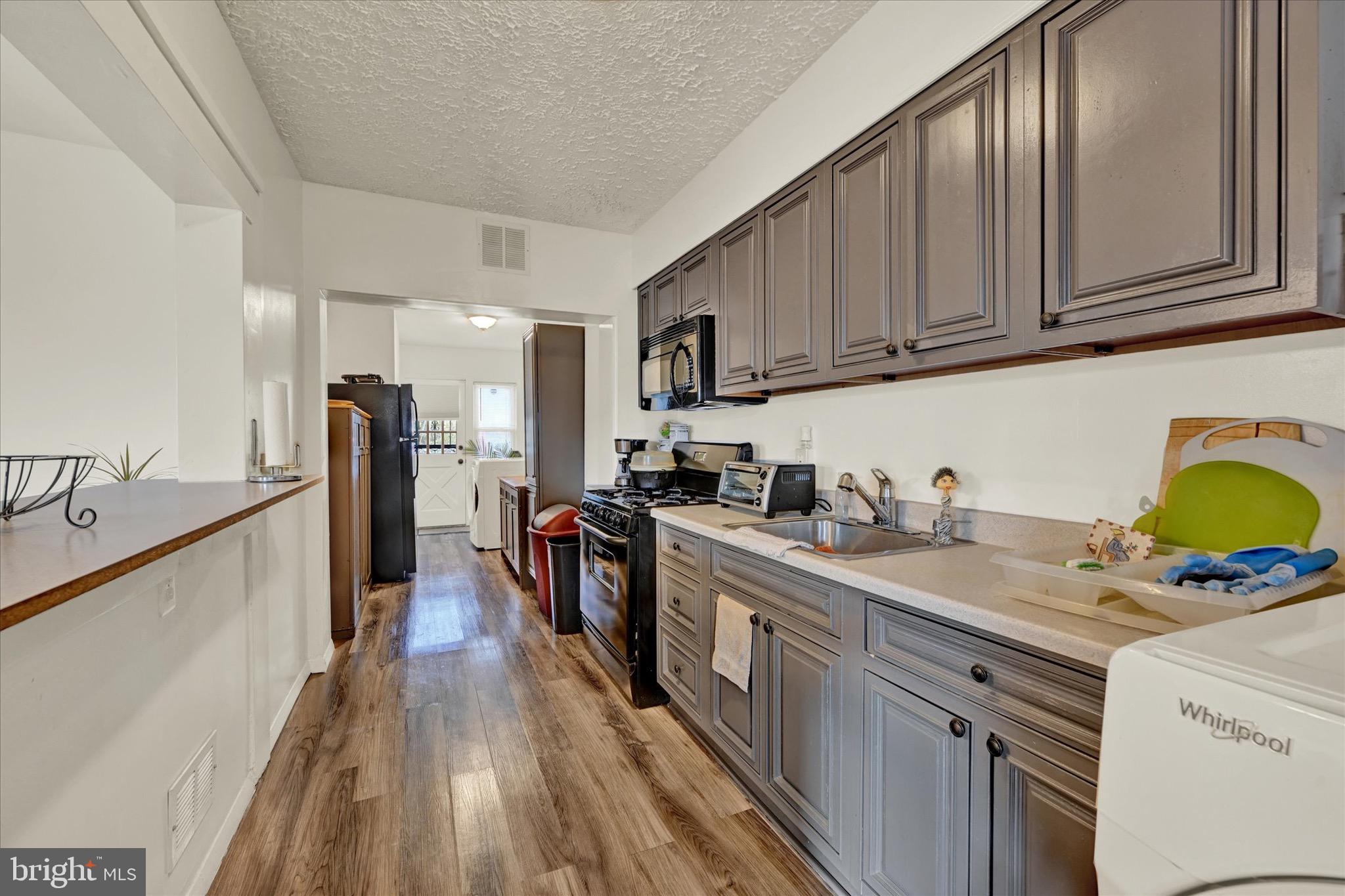 3922 Mortimer Avenue Baltimore, MD 21215 - Photo 11 of 27 a kitchen with stainless steel appliances granite countertop a sink stove refrigerator and cabinets