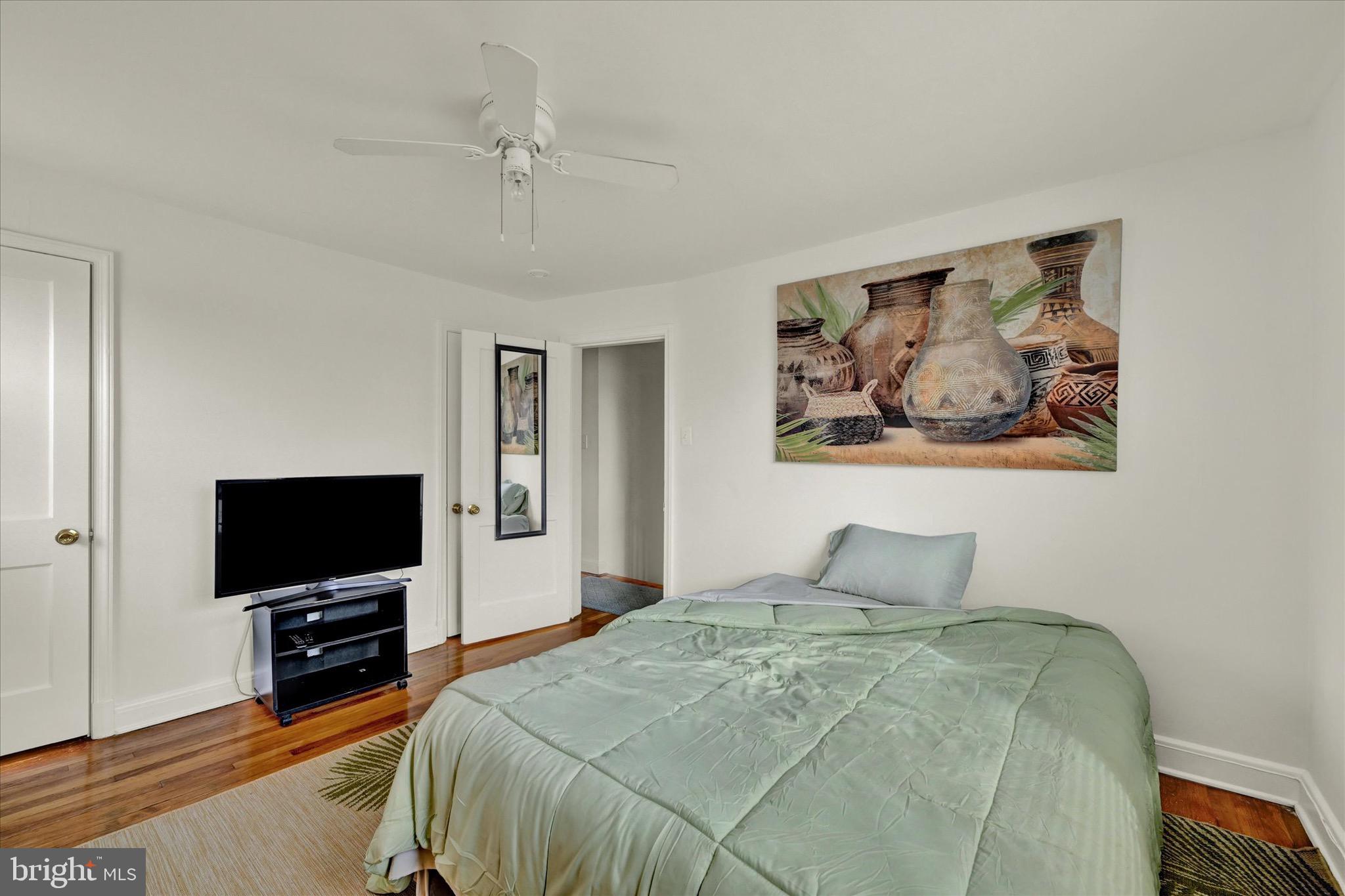 3922 Mortimer Avenue Baltimore, MD 21215 - Photo 14 of 27 a bedroom with a bed and a flat screen tv