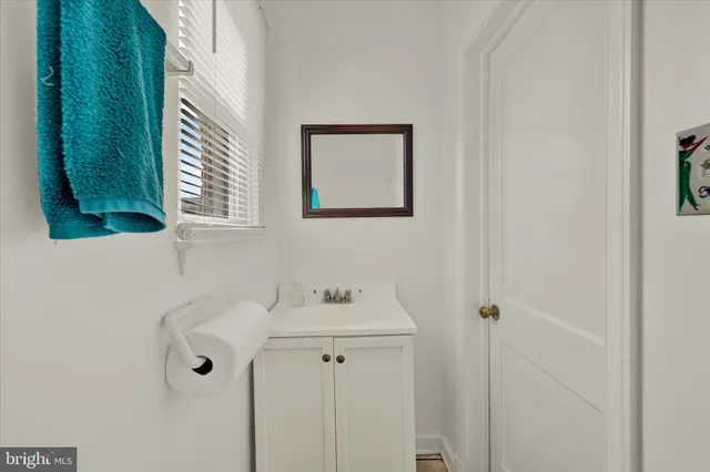 a bathroom with a sink and mirror with window