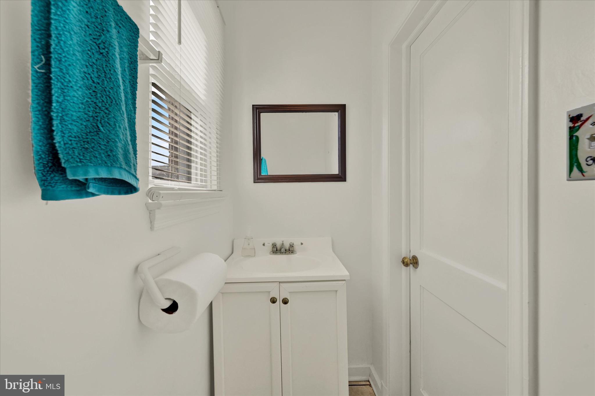 3922 Mortimer Avenue Baltimore, MD 21215 - Photo 18 of 27 a bathroom with a sink and mirror with window
