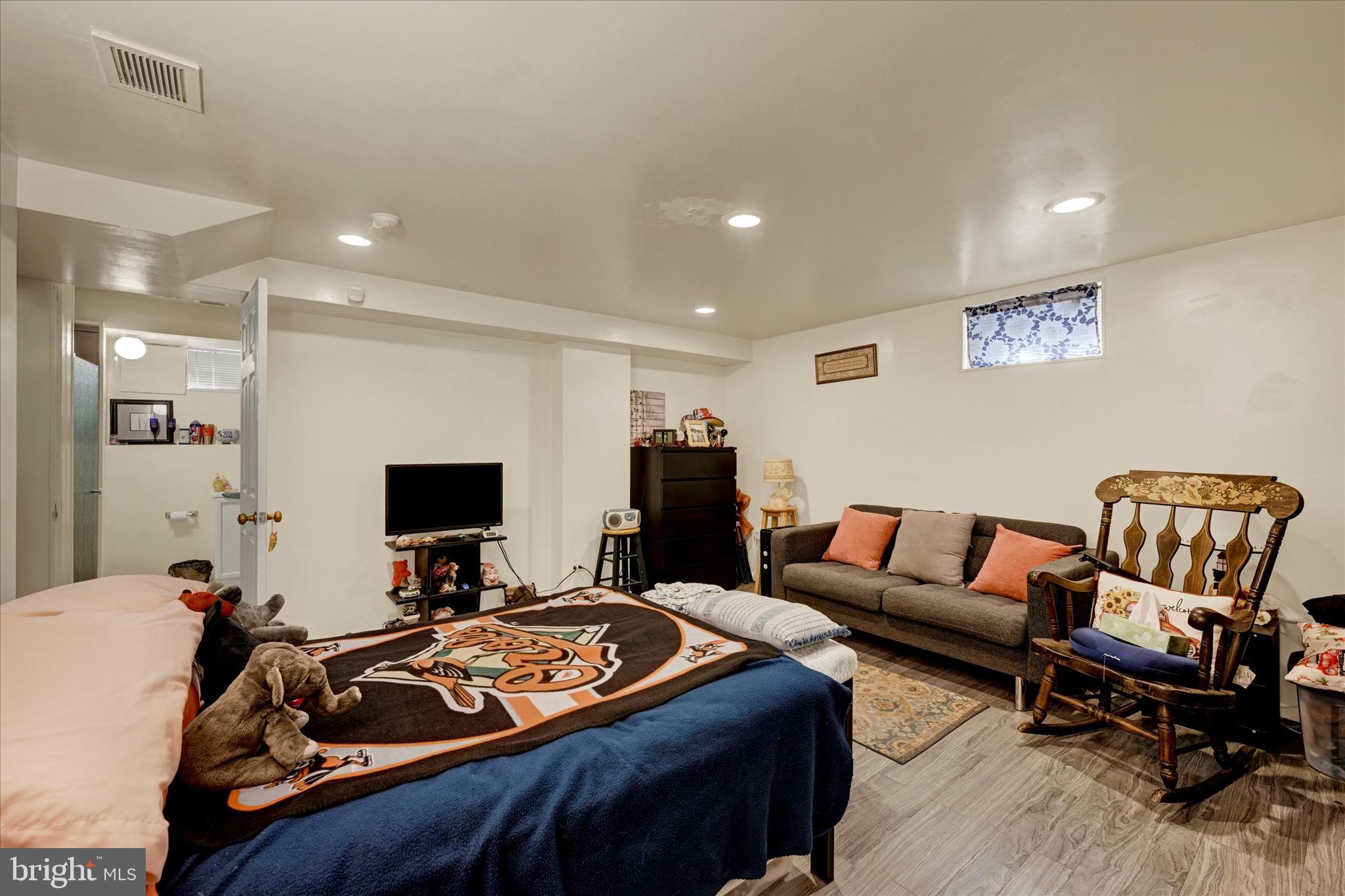 3922 Mortimer Avenue Baltimore, MD 21215 - Photo 22 of 27 a bedroom with furniture and a flat screen tv