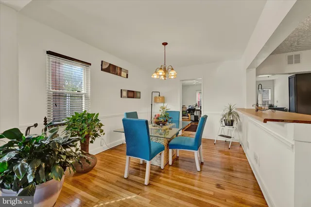 a dining room with furniture a chandelier and wooden floor