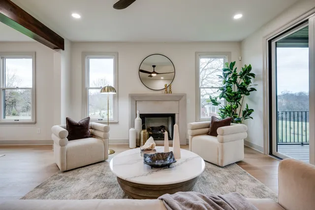 a living room with furniture a fireplace and a large window