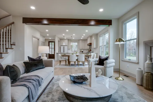 a living room with furniture a fireplace and a chandelier