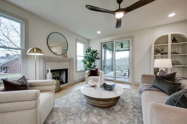 a living room with furniture a fireplace and a large window