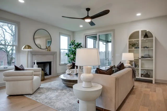 a living room with furniture a fireplace and a large window