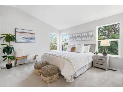 a bedroom with a bed and a large window