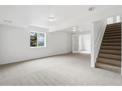 a view of an empty room with stairs and ventilation