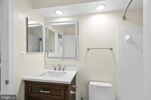 a bathroom with a sink a toilet a mirror and vanity