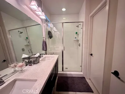 a bathroom with a double vanity sink a mirror and shower