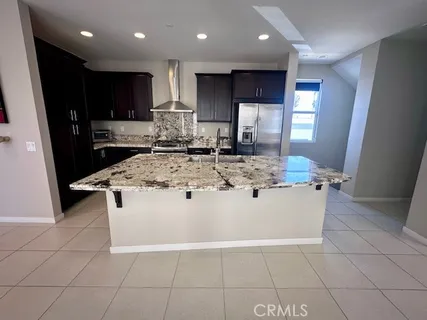 a view of kitchen with stainless steel appliances granite countertop a stove top oven a sink a counter top space and cabinets