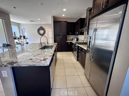 a kitchen with granite countertop a refrigerator and a counter top space