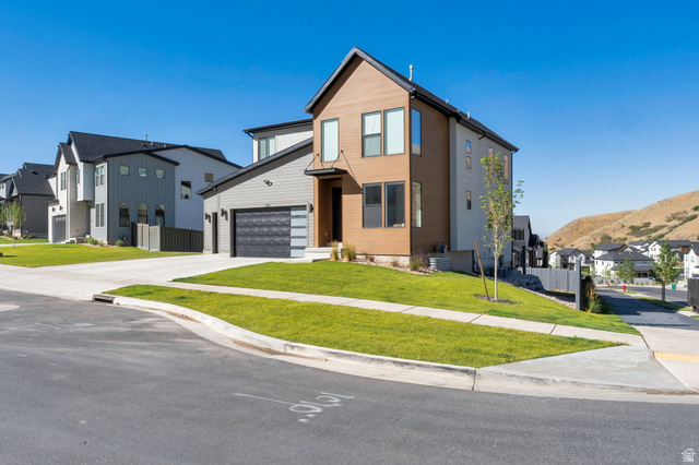 1711 West Canyon Rim Road North Lehi, UT 84048 - Photo 2 of 31 Contemporary exterior featuring multiple siding materials, a prominent front entry with an overhang, and a two-car garage with a modern door