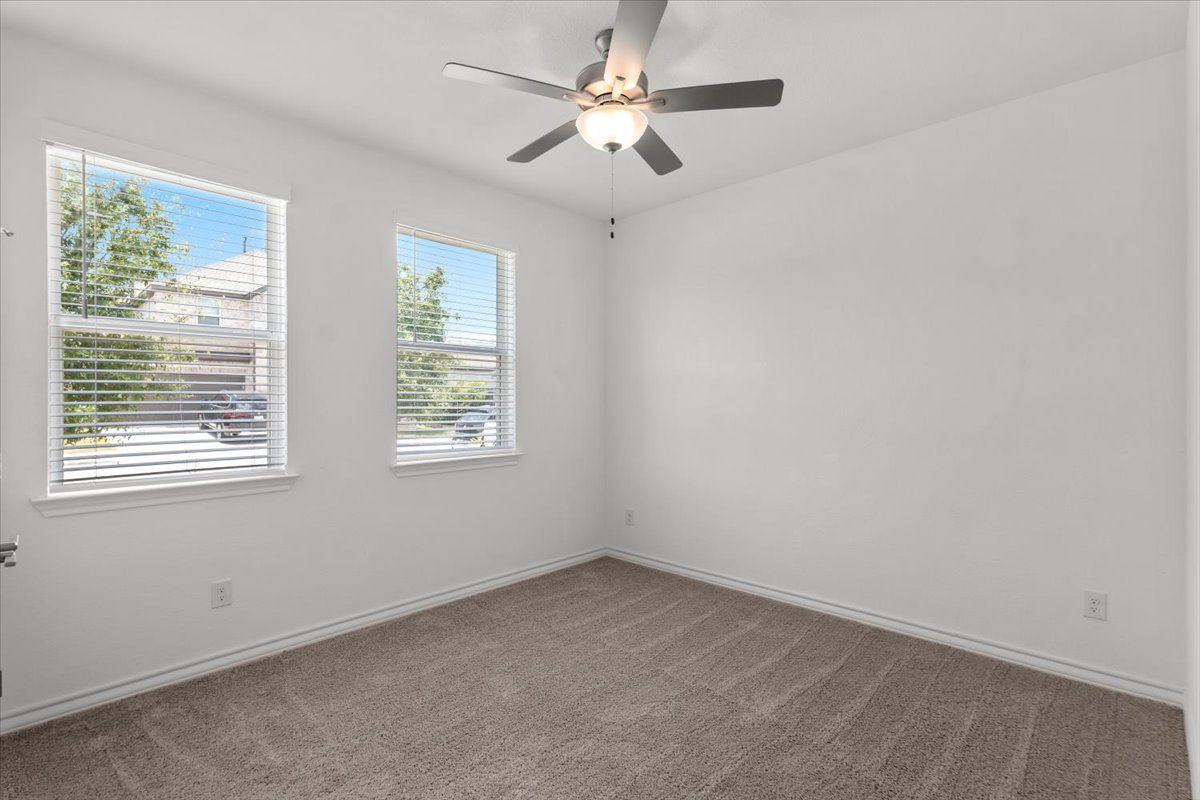 500 Stinchcomb Road Hutto, TX 78634 - Photo 29 of 37 A well-lit bedroom features plush carpet and an overhead ceiling fan for ultimate comfort.