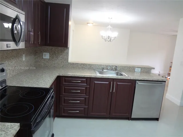 a kitchen with granite countertop a stove and a sink