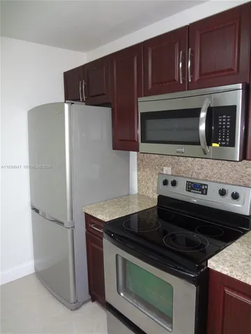 a kitchen with wooden cabinets and stainless steel appliances
