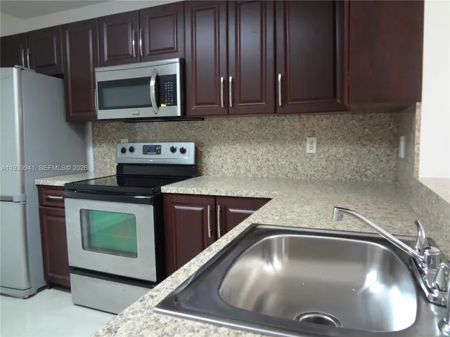 a kitchen with a stove microwave and sink
