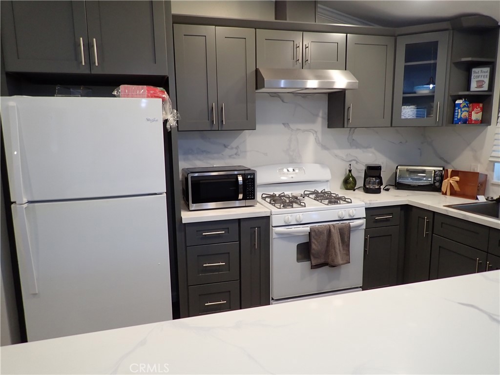 27250 Murrieta Road, Unit 386 Menifee, CA 92586 - Photo 9 of 32 a kitchen with stainless steel appliances a refrigerator sink and cabinets