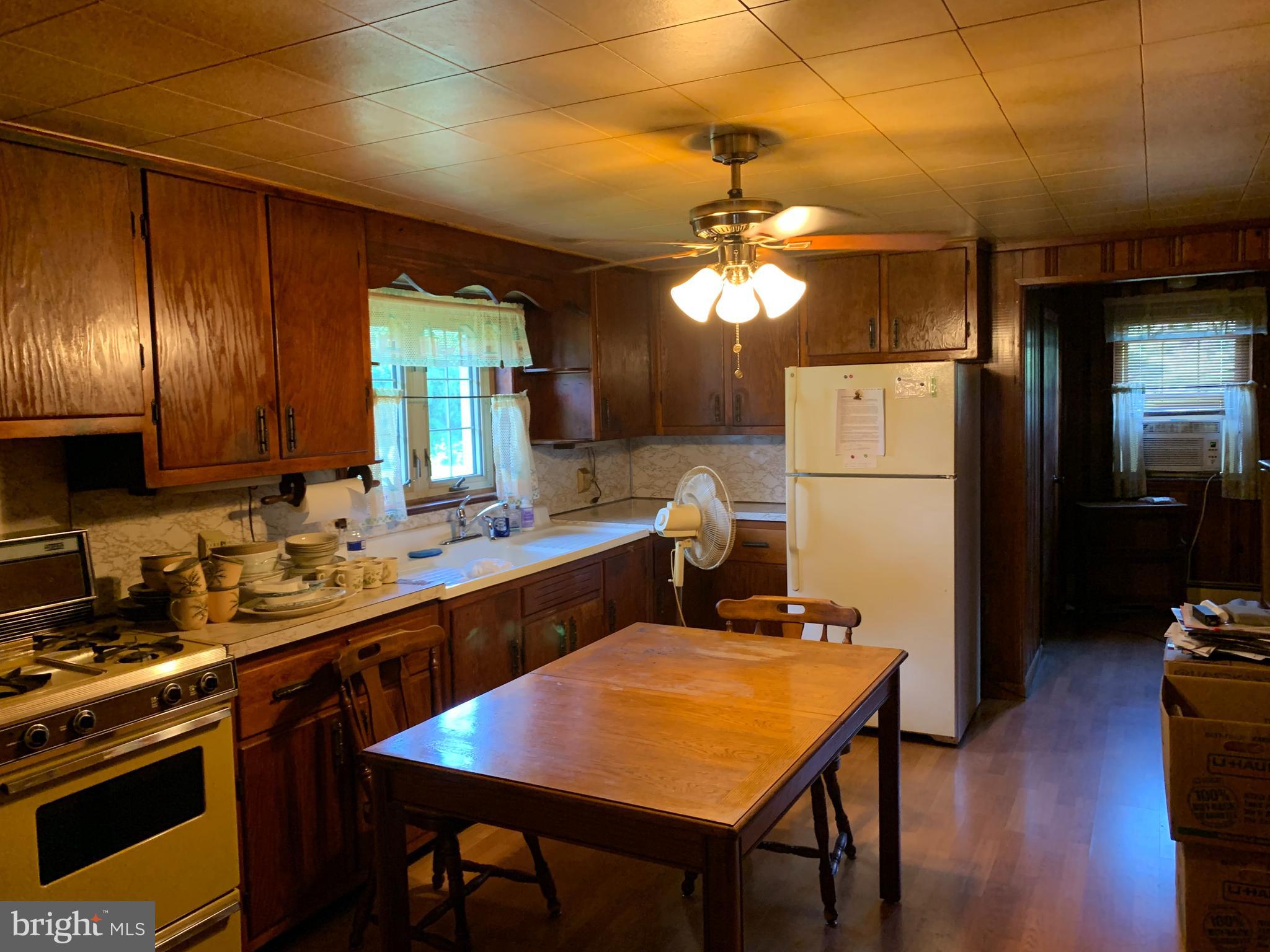 303 Meadowbrook Road Robbinsville, NJ 08691 - Photo 14 of 24 a kitchen with a refrigerator a stove and a dining table with wooden floor