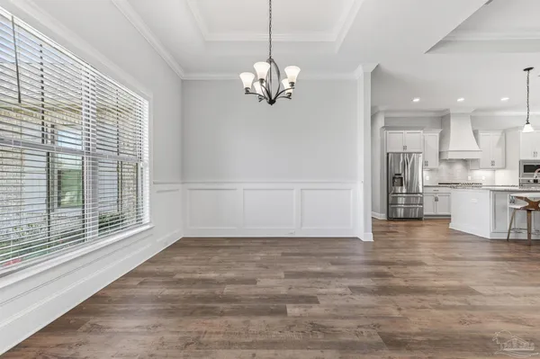 an empty room with wooden floor fireplace and staircase