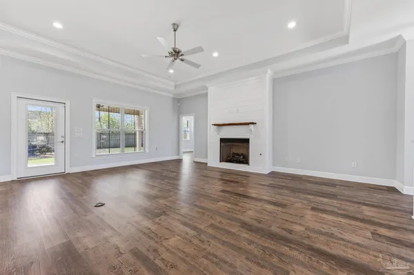 a view of empty room with wooden floor and window