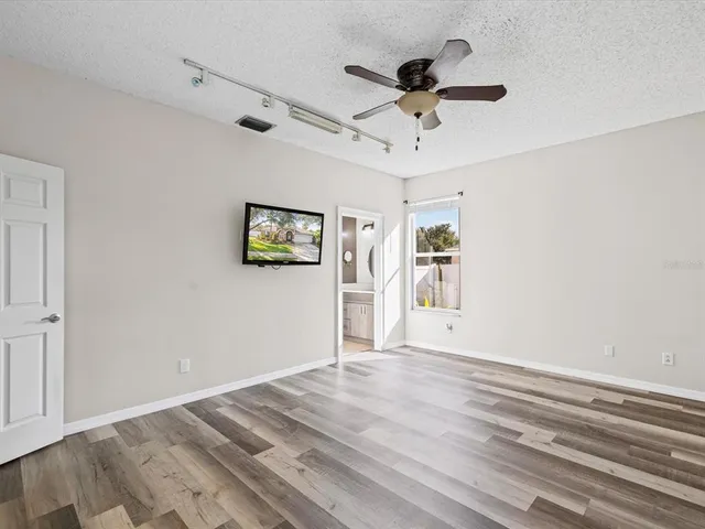 a view of empty room with wooden floor