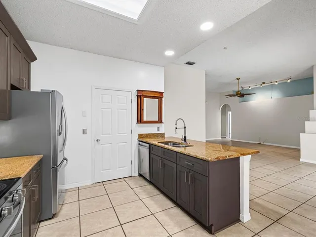 a kitchen with stainless steel appliances granite countertop a sink and a refrigerator