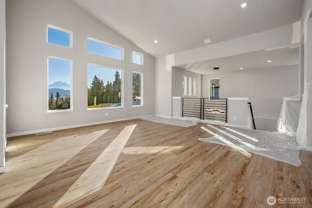 a view of empty room with wooden floor and windows