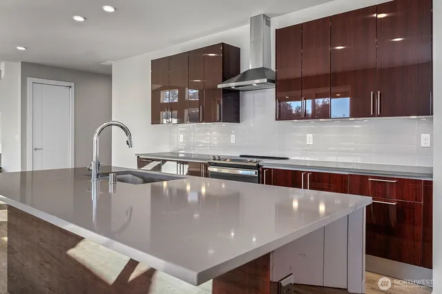 a large kitchen with stainless steel appliances a large counter top